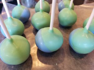Jack Skeleton Cake Pops dipping the green colored cake pop into the blue candy melts